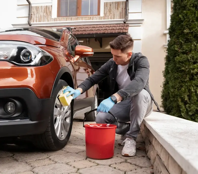 Lavage auto à domicile Châteaufort : professionnel intervenant sur un véhicule